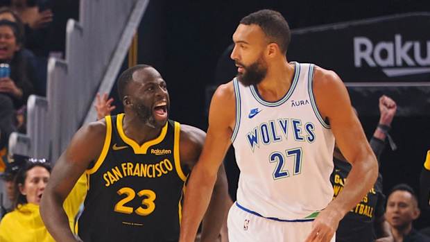 Nov 12, 2023; San Francisco, California, USA; Golden State Warriors forward Draymond Green (23) celebrates behind Minnesota Timberwolves center Rudy Gobert (27) after scoring a three point basket during the first quarter at Chase Center.